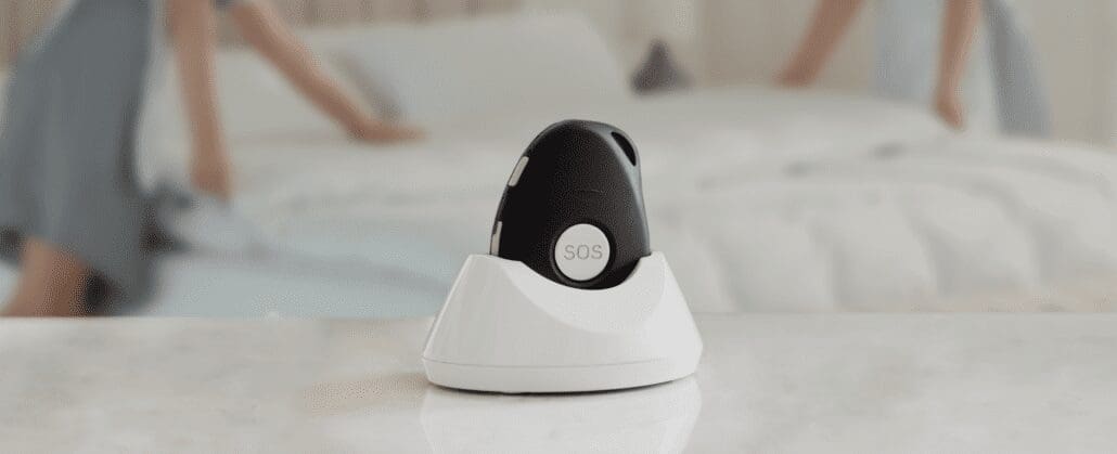 A picture of a simple noisemaker button with a housekeeper in the background.