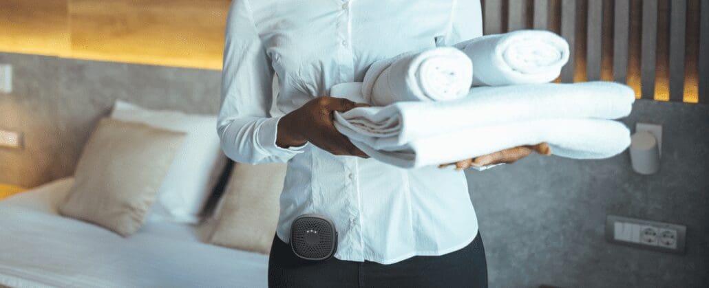 A housekeeper wearing a Relay device with a panic button feature.