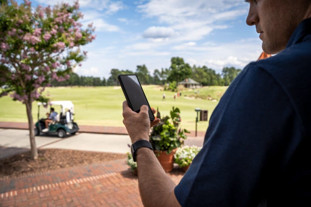 Man looking at phone on golf course