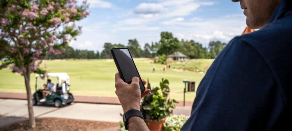 Man looking at phone on golf course