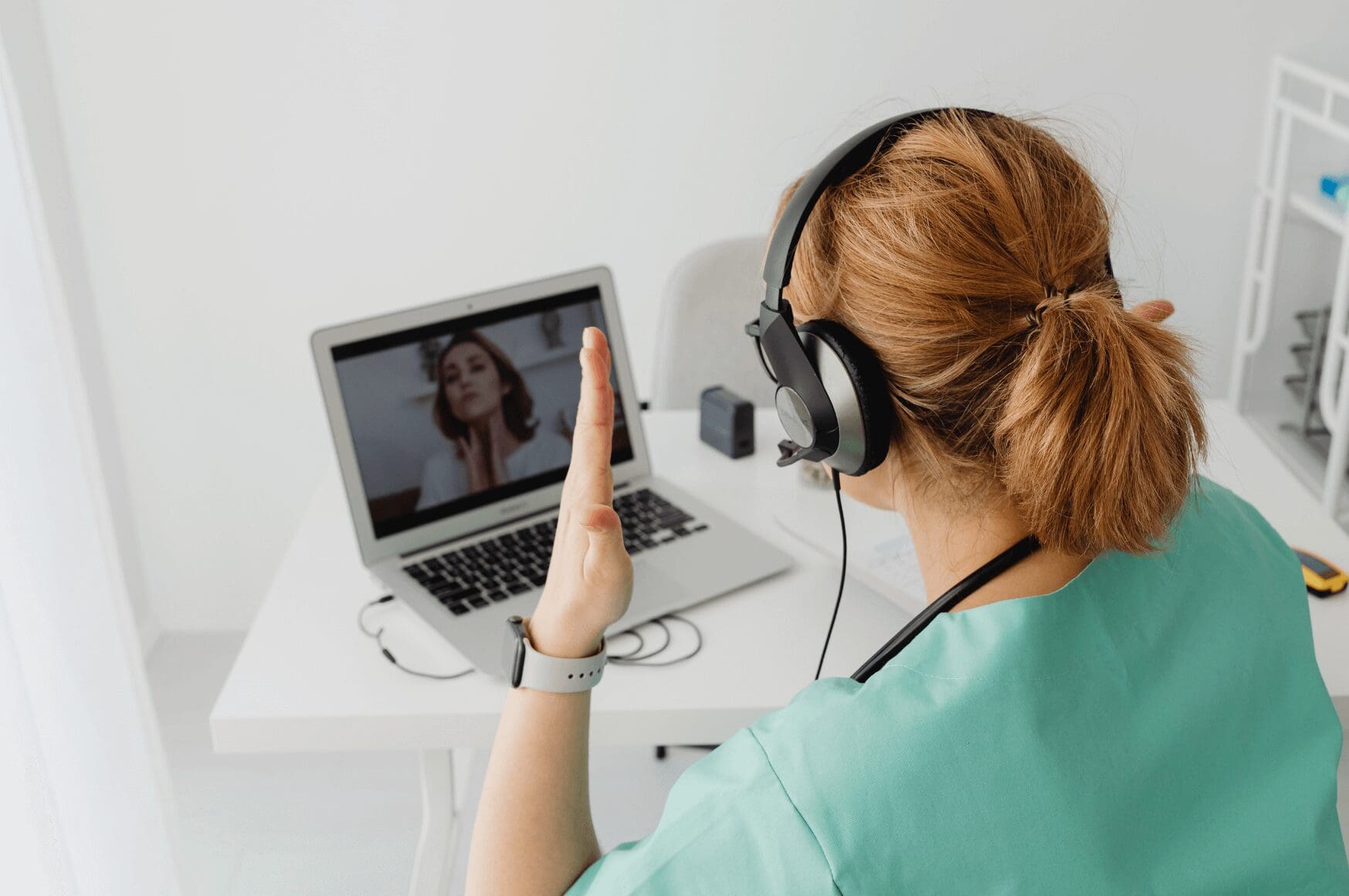 Healthcare professional communicating with a patient on a laptop