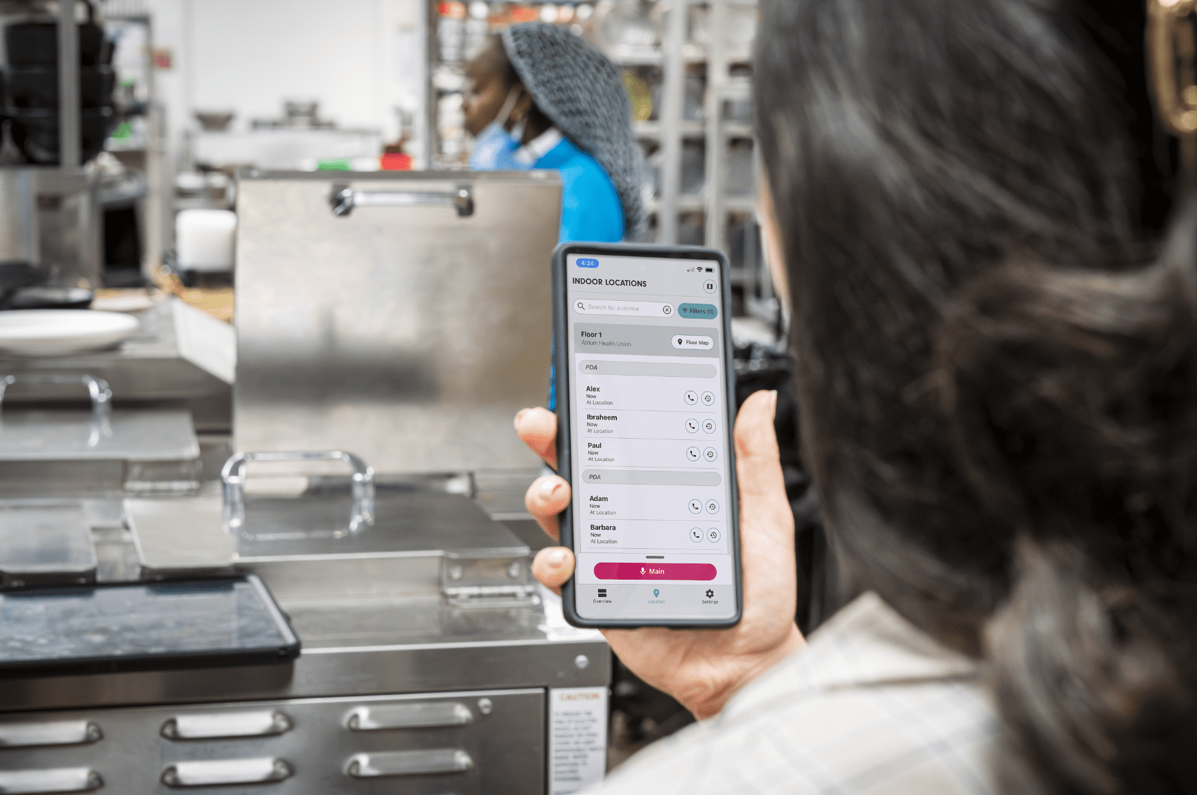 Frontline woman in food facility communicating on a cell phone with Relay App on screen