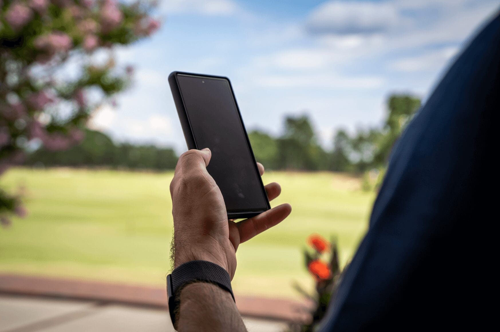 Man holding cell phone outside