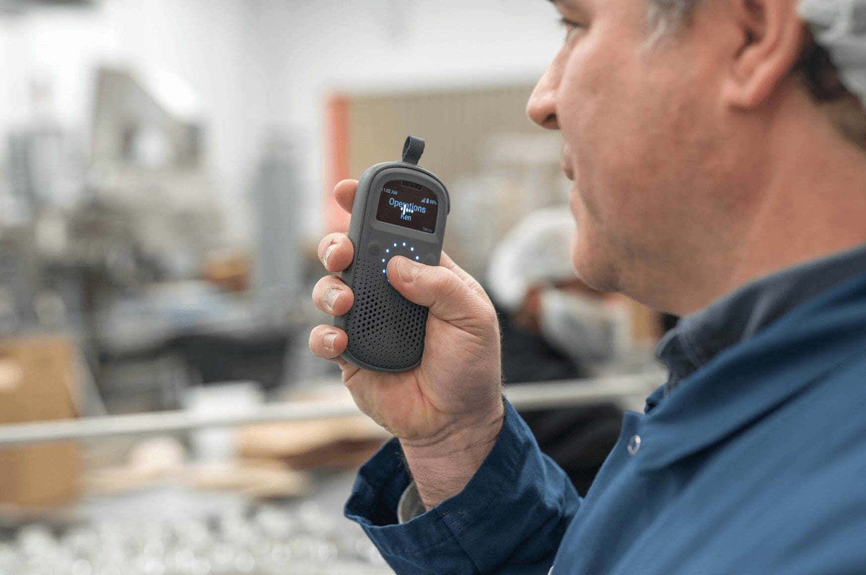 Man operating smart walkie talkie RelayX in an industrial facility
