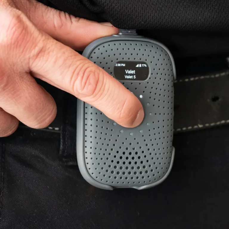Close-up of user pressing the RelayM device clipped to pants