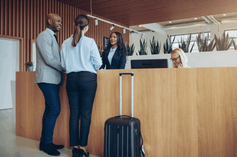 Man and woman checking into hotel reception desk