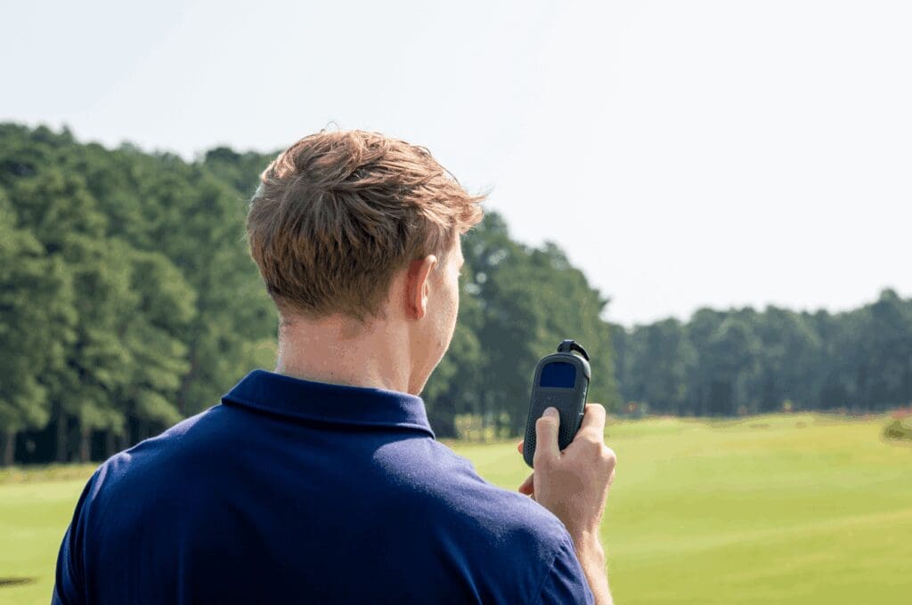 Man on golf course with his long distance walkie talkie Relay