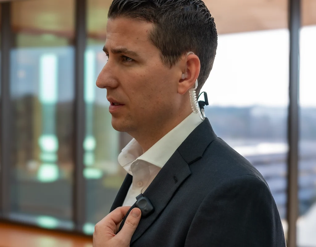 Casino security in a suit using Relay device with discreet earpiece for clear communication.