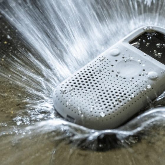Relay communication device being splashed with water, highlighting its durability and water resistance in rugged environments.